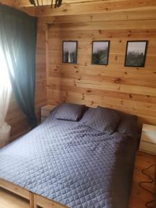 a bedroom with a bed in a log cabin at Sea You Soon w Sztutowie in Sztutowo
