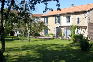 duży kamienny dom z trawnikiem w obiekcie La Châtaigne w mieście Piégut-Pluviers