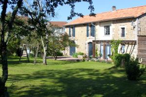 una gran casa de piedra con un patio de césped en La Châtaigne en Piégut-Pluviers