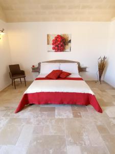 a bedroom with a large bed with red pillows at Masseria Signora Cecca in Fasano