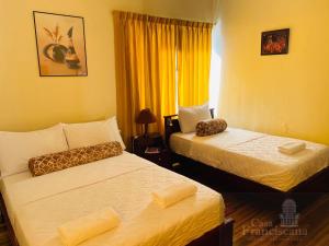 a hotel room with two beds and two lamps at Casa Franciscana in Quito