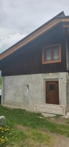 a house with a brown door and a window at Baita di montagna Stavel in Vermiglio
