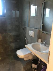 a bathroom with a toilet and a sink and a shower at Hotel Adriatik Ksamil in Ksamil