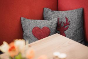 Un par de almohadas con un corazón rojo. en Avero Lodge en Samnaun