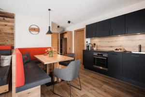 a kitchen with a table and a dining room at Avero Lodge by MEIN SAMNAUN - MOUNTAIN HOMES in Samnaun