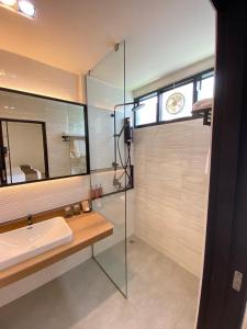 a bathroom with a sink and a mirror at The Gold Living Life in Thung Song