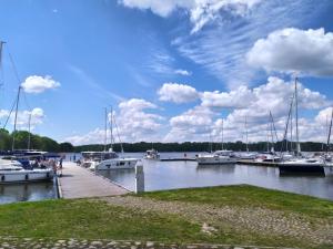 a group of boats docked at a dock on a lake at Apartament "Przy Jeziorku" in Kętrzyn