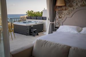 a bedroom with a bed and a tub on a balcony at HOLM Boutique & SPA - IK Collection in St. Julianʼs