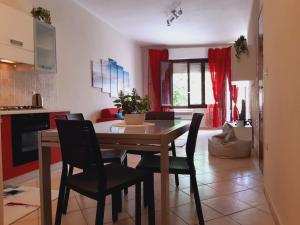 アルゲーロにあるBrisa Marina apartmentのキッチン、ダイニングルーム(木製のテーブルと椅子付)