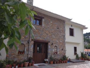 a brick house with a door and some plants at Evridiki in Zagora