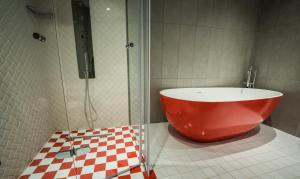 a shower with a large red tub in a bathroom at HOLM Boutique & SPA - IK Collection in St. Julianʼs