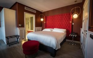 a bedroom with a large bed and a red wall at HOLM Boutique & SPA - IK Collection in St Julian's