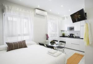 - une chambre blanche avec un canapé blanc et une table dans l'établissement Salamanca Confort Peñalver en Madrid Capital, à Madrid