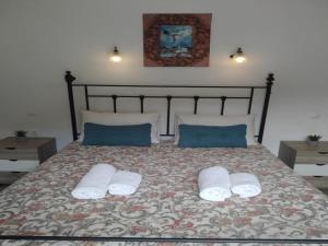 a bed with two pillows and two towels on it at Rio Grande Rooms in Benitses