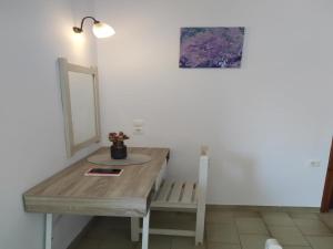 a room with a wooden table and a mirror at Rio Grande Rooms in Benitses