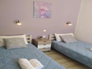 1 dormitorio con 2 camas y mesita de noche en Rio Grande Rooms, en Benitses