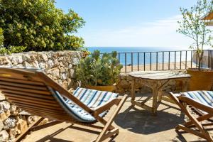 une terrasse avec une table et des chaises et l'océan dans l'établissement Casa Vacanze De Vita - Amazing view on the coast - Suite with outdoor Jacuzzi, à Marina Serra