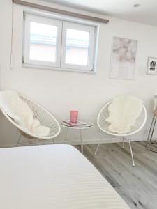 um quarto com duas cadeiras, uma mesa e uma janela em Appartement Blanc cocooning em Sprimont