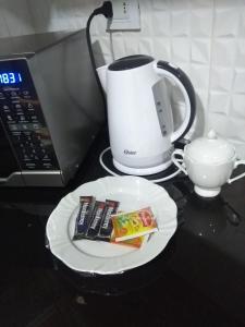 a plate on a counter with a coffee maker and a cup at Práctico Smart Studio in Santa Cruz de la Sierra