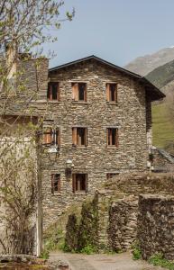 un antiguo edificio de piedra con muchas ventanas en Casa Mora Vall Fosca en Central