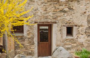 un antiguo edificio de piedra con puerta de madera en Casa Mora Vall Fosca en Central