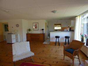a living room with two chairs and a kitchen at Familiehuis Achter de Duijnhoeve Bakkum in Zuidbakkum