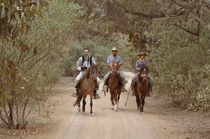 three people riding horses down a dirt road at Rancho Santana Horseback Riding in Pacora