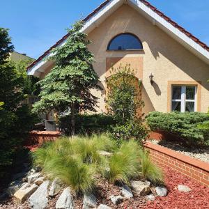 una casa con un árbol delante de ella en Domek blisko plazy en Świnoujście