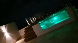 a swimming pool at night with a green light at Peixe Gordo Hotel in Icapuí
