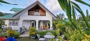 een huis met een balkon en een tafel en stoelen bij CHEZ MARVA Grande Villa Corossol 3 à 12 personnes in La Digue