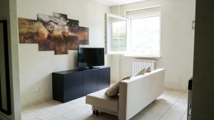 sala de estar con sofá blanco y TV en ApartHotel Le Sirene - CHALET, en Tívoli