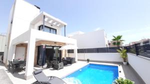 a villa with a swimming pool and a house at Villa Wilhelmina in Torrevieja