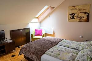 a bedroom with a bed and a chair and a window at Pleasure Čair apartments in Niš