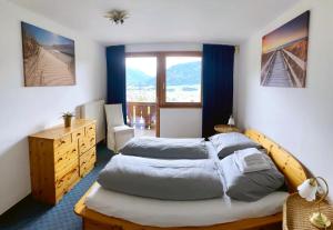 a bedroom with two beds and a dresser and a window at Gasthof PANORAMA in Ehrwald