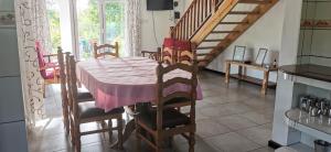 una sala da pranzo con tavolo, sedie e scala di CHEZ MARVA Grande Villa Corossol 3 à 12 personnes a La Digue Altre 19 foto