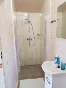 a bathroom with a shower and a sink at Domki Niezapominajka Ustka in Ustka