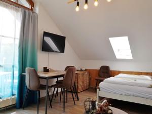 SchöfwegにあるFerienwohnung 32 im Ferienland Sonnenwald - Bayerischer Waldのベッドルーム1室(ベッド1台、テーブル、椅子付)