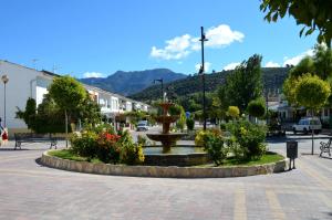 a fountain in the middle of a town with flowers at Vivienda rural Mogón-Junto al Guadalquivir B in Villacarrillo