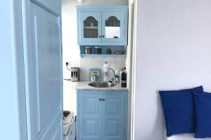 a bathroom with a sink and a blue cabinet at Blue Moon Villa in Imerovigli +16 photos