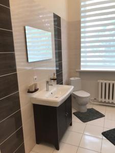 un baño con lavabo e inodoro en KK apartments, en Liepāja 40 fotos más