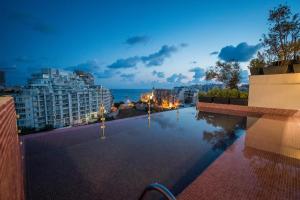 a swimming pool with a view of a city at night at HOLM Boutique & SPA - IK Collection in St. Julianʼs