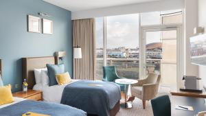 a hotel room with two beds and a window at voco St. David's Cardiff by IHG in Cardiff
