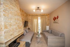 un soggiorno con divano e muro di mattoni di Villa Vergia a Sozopoli