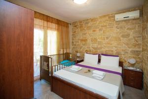 1 dormitorio con cama y pared de piedra en Villa Vergia en Sozópolis