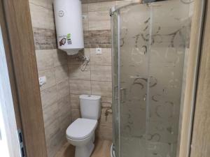 a bathroom with a toilet and a glass shower at Tęczowe Lato in Sarbinowo +14 photos