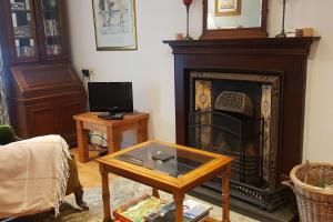 a living room with a fireplace and a coffee table at Cosy Townhouse on The Hill in Ireland in Banagher