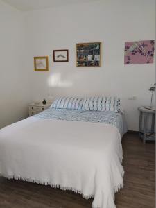 1 dormitorio con 1 cama con colcha blanca en Vivienda rural Mogón-Junto al Guadalquivir B en Villacarrillo