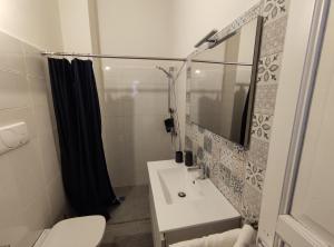 a bathroom with a sink and a mirror and a toilet at Xeniahome in Castelvetrano Selinunte