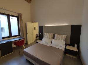 a bedroom with a bed and a desk and a window at Xeniahome in Castelvetrano Selinunte