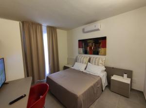 a bedroom with a bed and a desk and a television at Xeniahome in Castelvetrano Selinunte